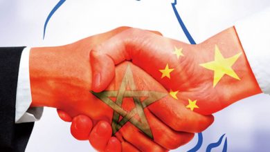 Handshake of two hands, on one is the Moroccan flag and on the other is the Chinese flag.