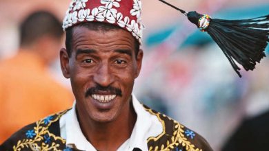 A happy Moroccan man wearing traditional Moroccan Gnawa clothes