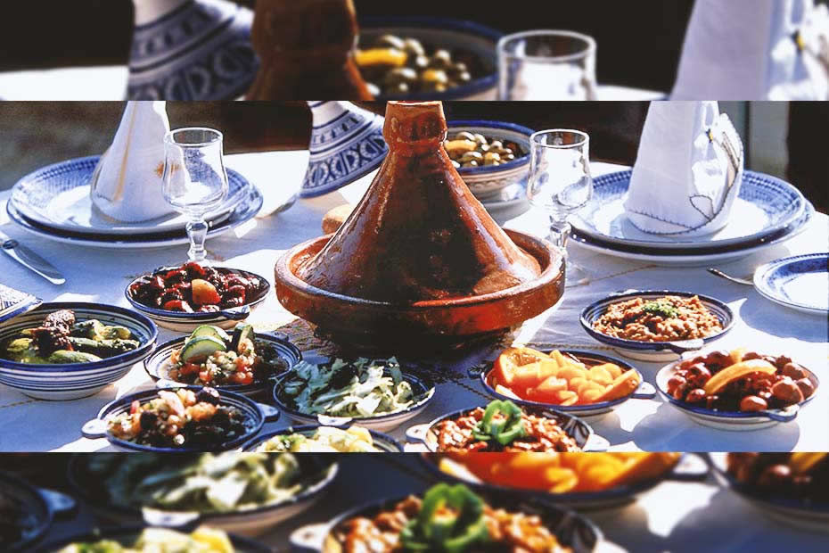 a table withe plates of salads and a tajine in the middle